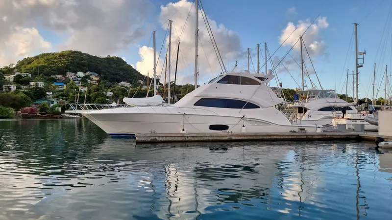 Slide: The Image of 2009 Bertram 700 Enclosed yacht docked in a serene marina. - 2