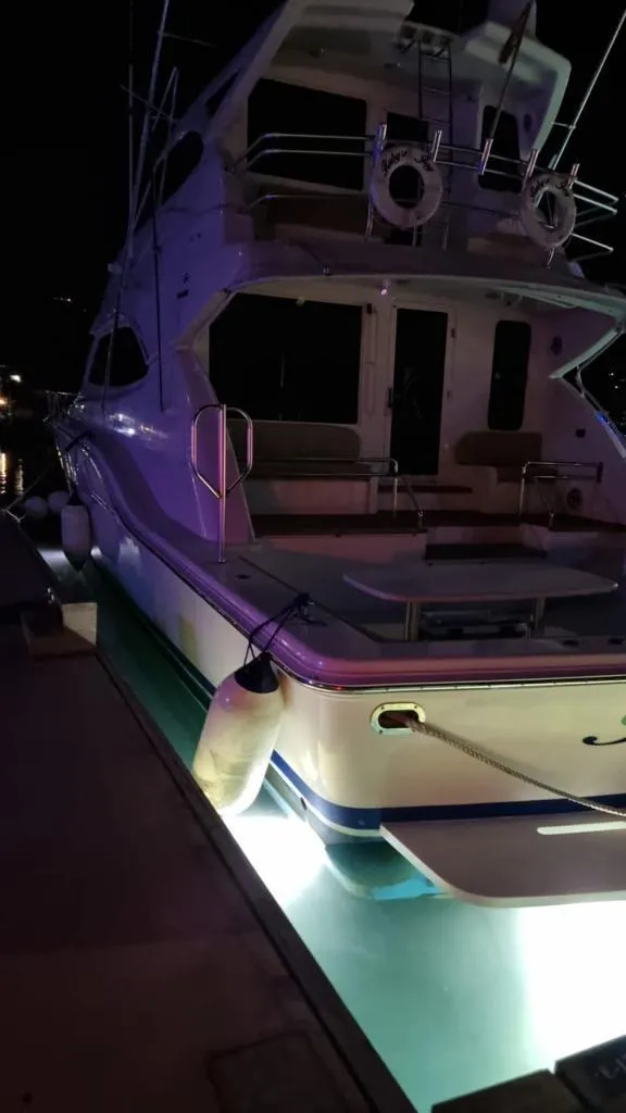 Slide: The Image of 2009 Bertram 700 Enclosed yacht docked at night with underwater lights. - 22
