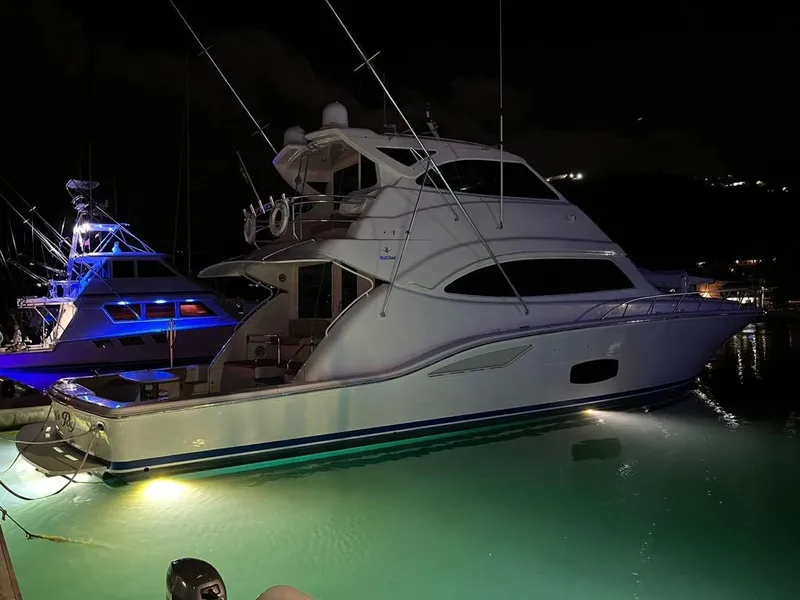 Slide: The Image of 2009 Bertram 700 Enclosed yacht illuminated at night in a marina. - 23