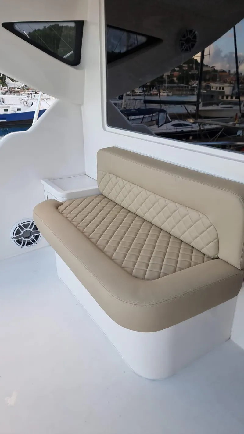 Slide: The Image of 2009 Bertram 700 Enclosed boat with beige cushioned seating. - 6