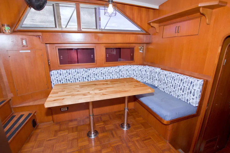 Slide: The Image of Cozy dining area in 1994 Jefferson Marquessa 56 yacht with wooden table and cushioned seating. - 57