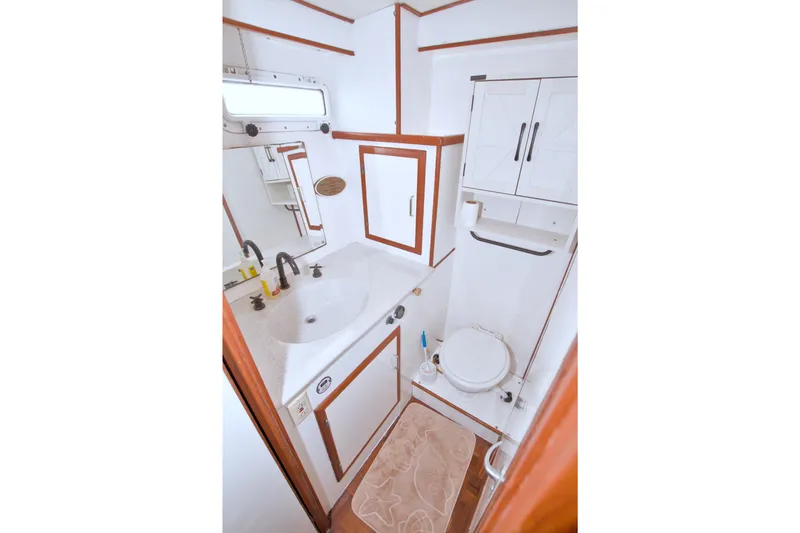 Slide: The Image of Bathroom interior of 1994 Jefferson Marquessa 56 yacht, featuring sink, mirror, and toilet. - 80