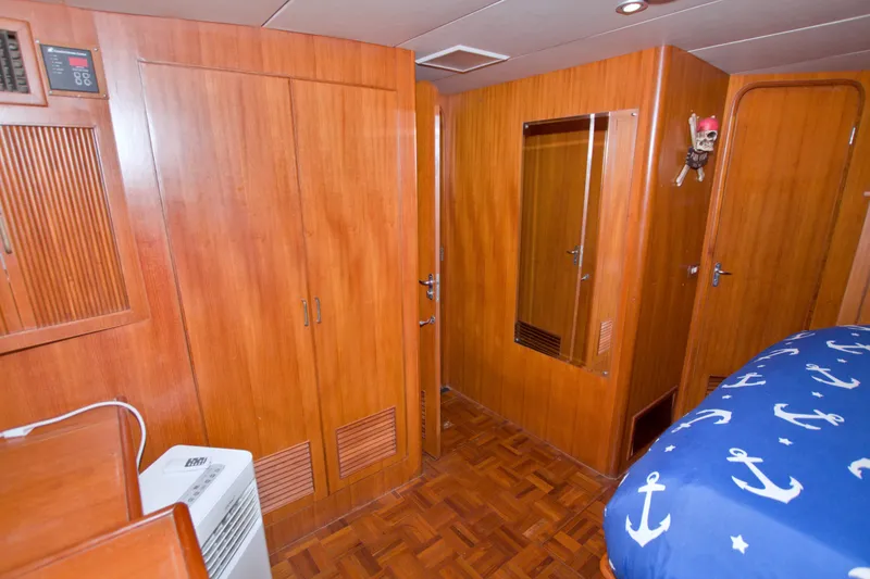 Slide: The Image of Interior of 1994 Jefferson Marquessa 56 yacht with wood paneling and nautical-themed bedding. - 90