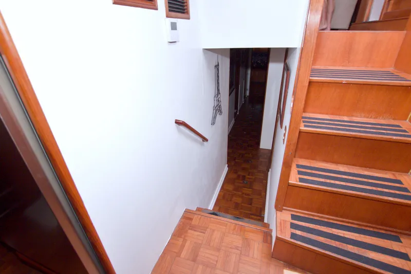 Slide: The Image of Staircase inside 1994 Jefferson Marquessa 56 Extended Deckhouse yacht, featuring wooden steps and handrail. - 71