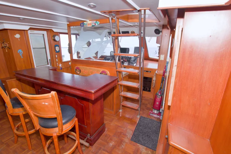 Slide: The Image of Interior of 1994 Jefferson Marquessa 56 yacht with bar, seating, and ladder to helm. - 25