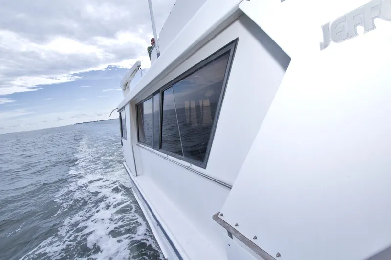 Slide: The Image of 1994 Jefferson Marquessa 56 yacht cruising on open water under cloudy skies. - 50