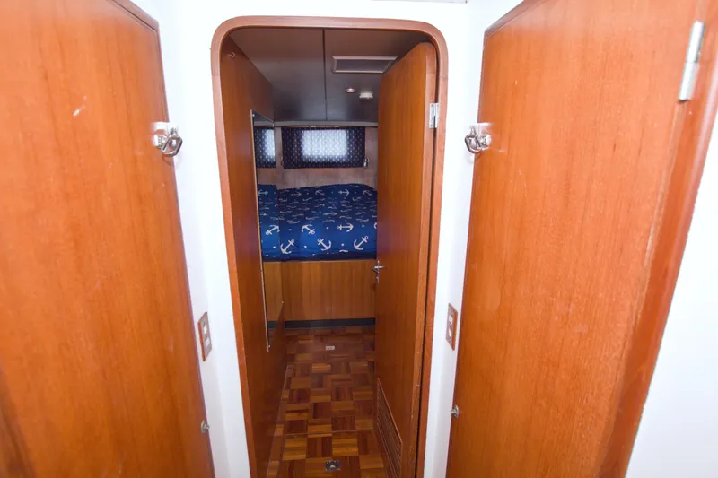 Slide: The Image of Interior hallway of 1994 Jefferson Marquessa 56 yacht with wooden doors and nautical-themed bedding. - 87