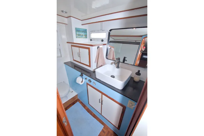 Slide: The Image of Bathroom interior of 1994 Jefferson Marquessa 56 yacht, featuring sink, mirror, and storage cabinets. - 94