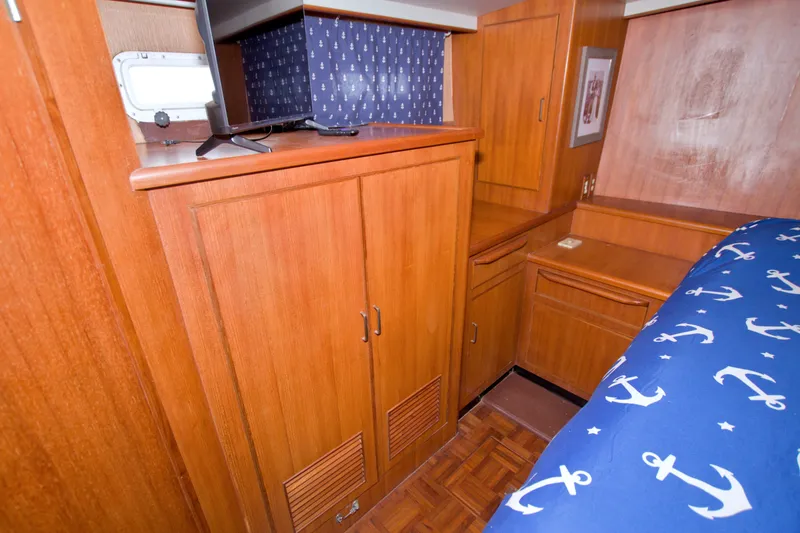Slide: The Image of Cozy cabin interior of 1994 Jefferson Marquessa 56 yacht with wooden cabinetry and nautical bedding. - 92
