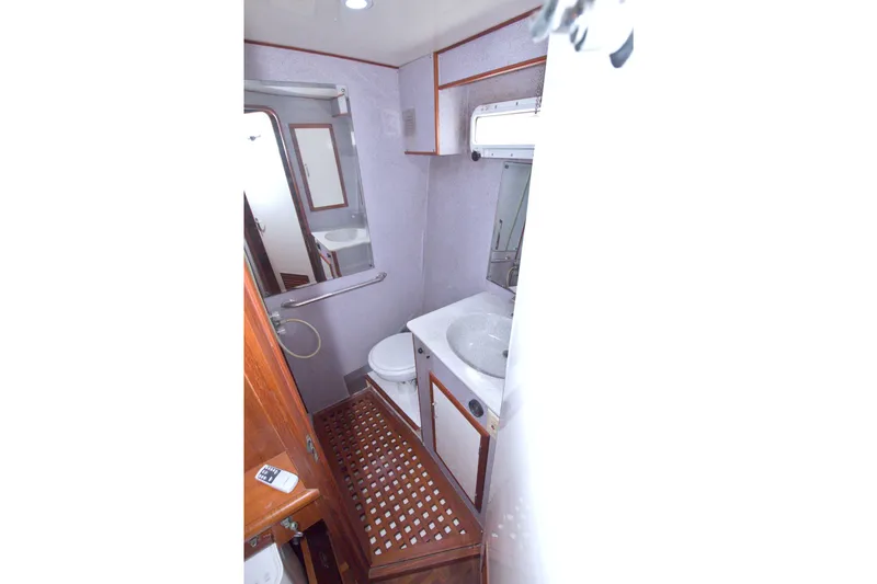 Slide: The Image of Bathroom interior of 1994 Jefferson Marquessa 56 yacht, featuring sink, toilet, and wooden accents. - 76