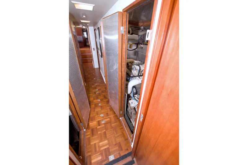 Slide: The Image of Narrow hallway inside 1994 Jefferson Marquessa 56 yacht, featuring wooden flooring and engine room access. - 116