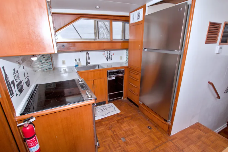 Slide: The Image of Kitchen interior of 1994 Jefferson Marquessa 56 yacht with modern appliances and wooden cabinetry. - 58