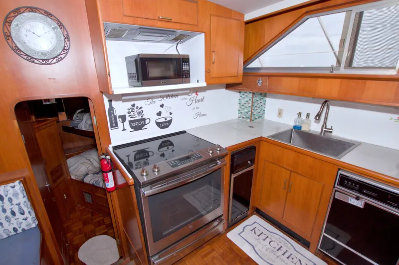 Slide: The Image of 1994 Jefferson Marquessa 56 yacht kitchen with stove, microwave, and sink. - 59
