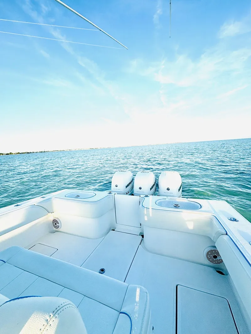 Slide: The Image of 2023 SeaHunter 33 boat on open water with triple outboard engines. - 2