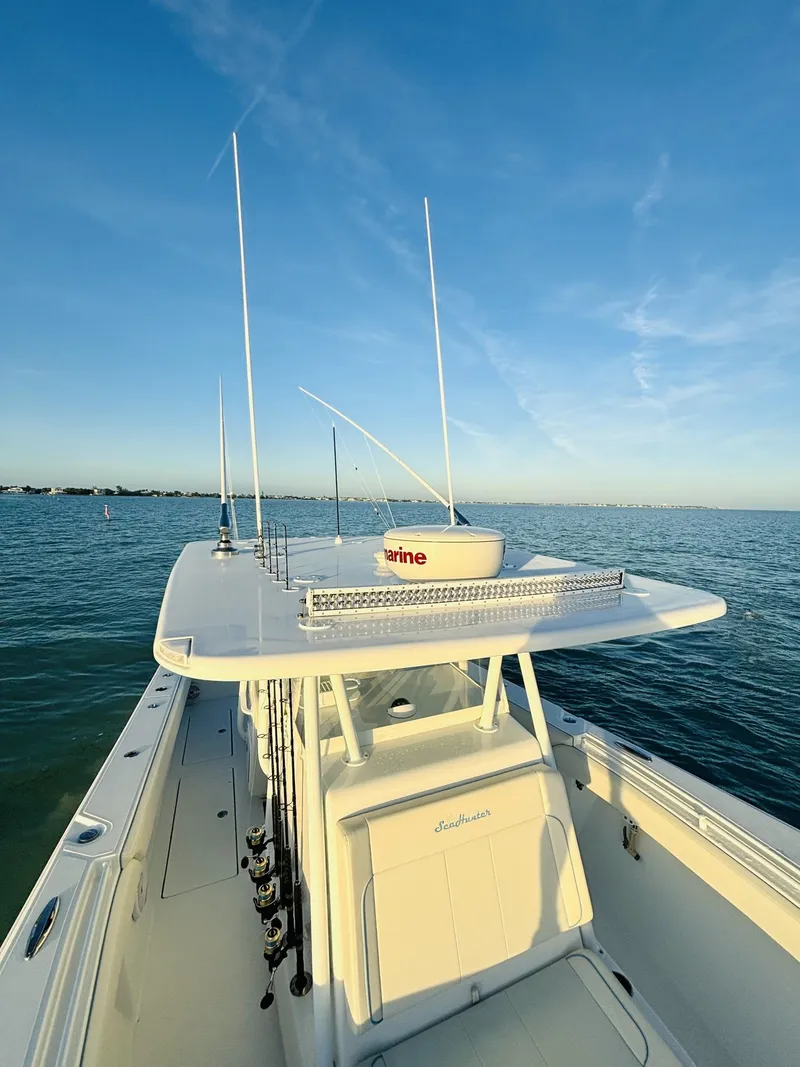 Slide: The Image of 2023 SeaHunter 33 boat on calm waters under a clear blue sky. - 6