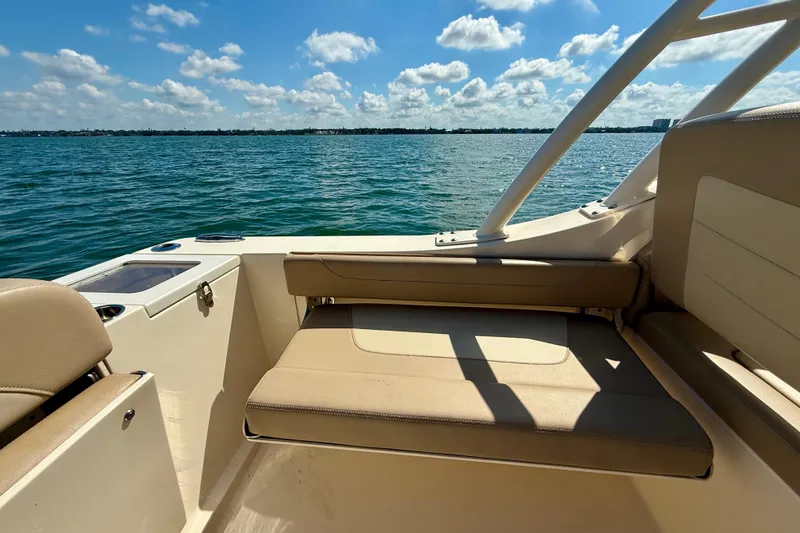 Slide: The Image of 2024 Scout 240 Dorado boat interior with seating, overlooking calm blue waters. - 11