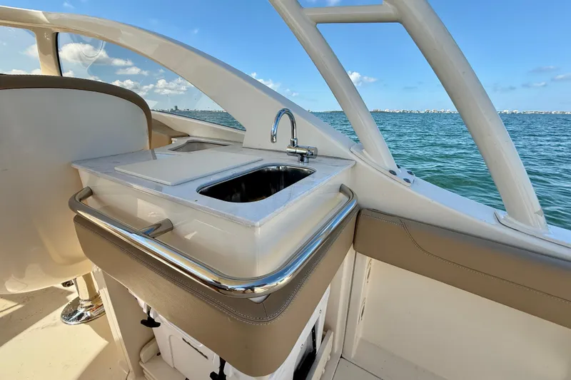 Slide: The Image of 2024 Scout 240 Dorado boat interior with sink, overlooking ocean view. - 12