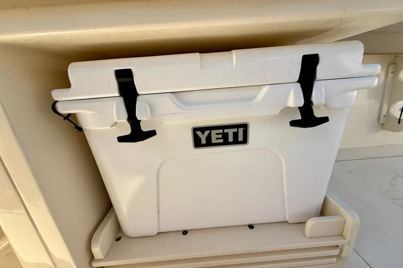 Slide: The Image of White YETI cooler on 2024 Scout 240 Dorado boat, securely stored under a seat. - 13