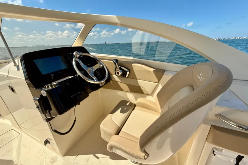 Slide: The Image of 2024 Scout 240 Dorado boat interior with steering wheel and luxurious seating. - 14