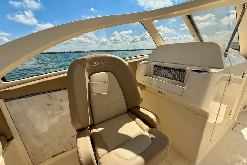 Slide: The Image of 2024 Scout 240 Dorado boat interior with beige seating and ocean view. - 17