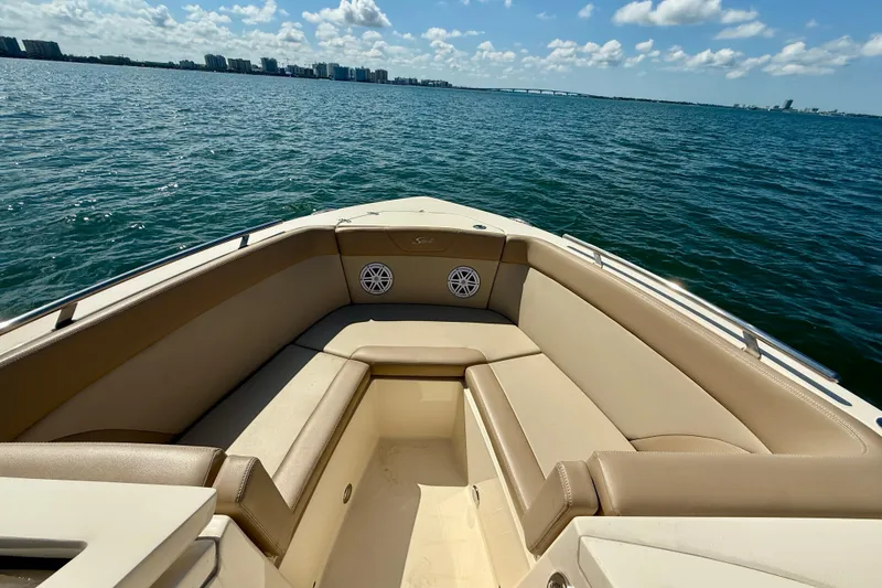 Slide: The Image of 2024 Scout 240 Dorado boat interior with beige seating, overlooking calm blue waters. - 20