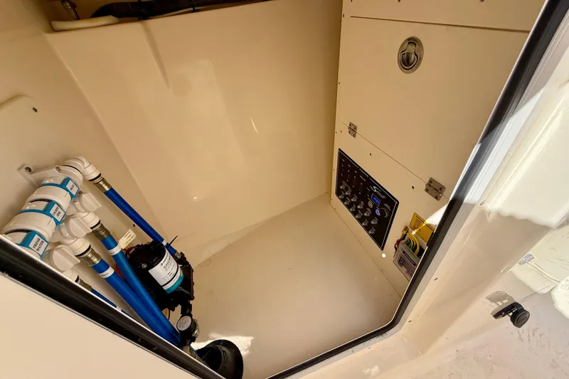 Slide: The Image of 2024 Scout 240 Dorado boat interior showing control panel and plumbing system. - 22