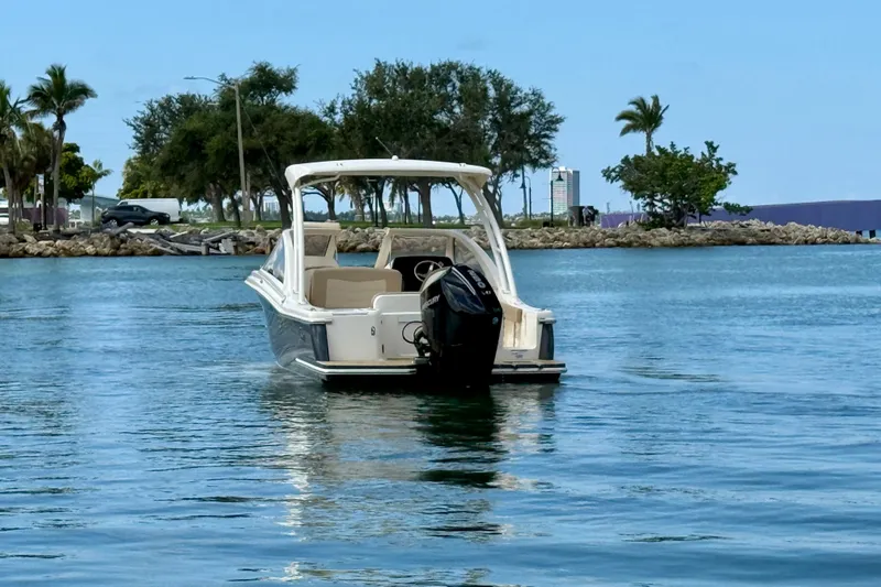 Slide: The Image of 2024 Scout 240 Dorado boat on calm water near a scenic shoreline. - 3