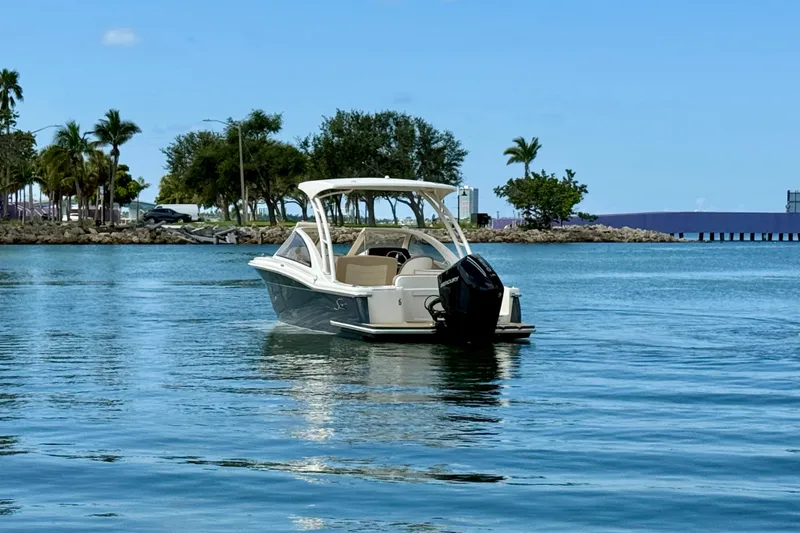 Slide: The Image of 2024 Scout 240 Dorado boat on calm water with scenic background. - 4