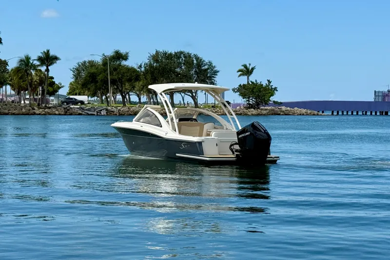 Slide: The Image of 2024 Scout 240 Dorado boat cruising on calm blue waters near a tropical shoreline. - 5