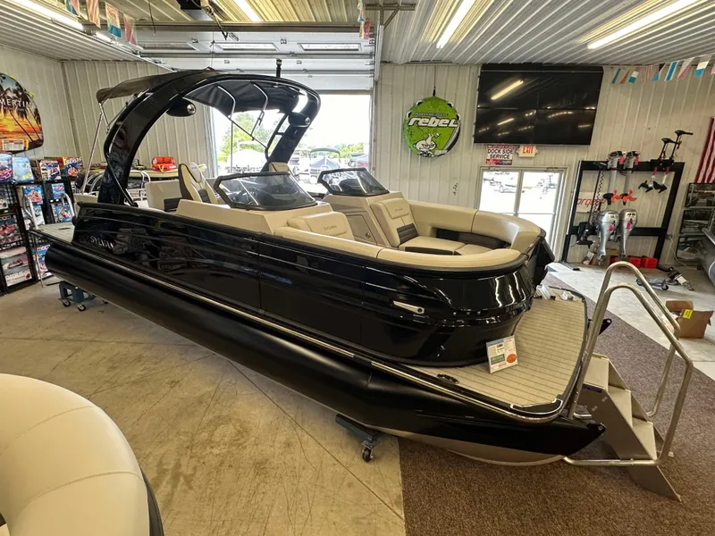 Slide: The Image of 2024 Sylvan G3 CLZ DC pontoon boat in showroom, sleek black design, luxury seating. - 4
