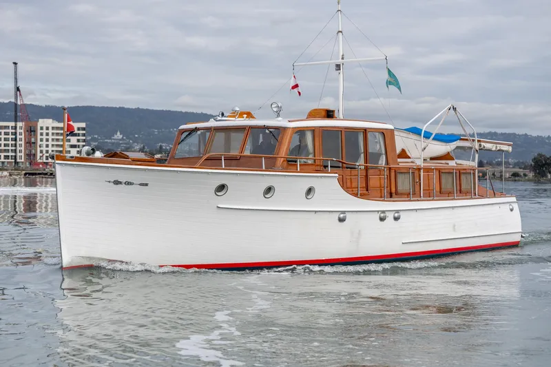 Slide: The Image of 1939 Stephens Brothers Bridgedeck Cruiser on calm water, showcasing classic wooden design. - 1