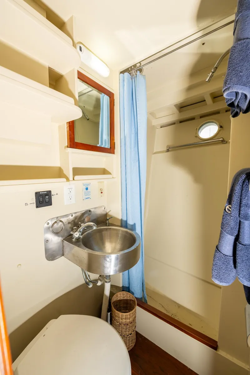 Slide: The Image of 1939 Stephens Brothers Bridgedeck Cruiser bathroom with sink, shower, and blue towels. - 15