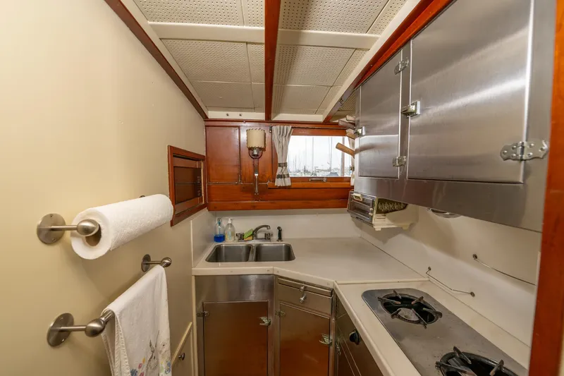 Slide: The Image of 1939 Stephens Brothers Bridgedeck Cruiser kitchen with stainless steel appliances and wooden accents. - 19
