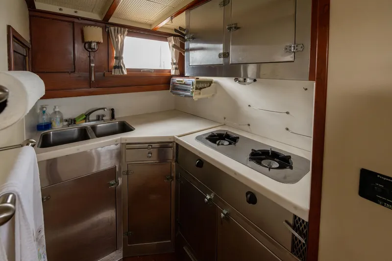 Slide: The Image of 1939 Stephens Brothers Bridgedeck Cruiser kitchen with stainless steel appliances and wooden cabinetry. - 24