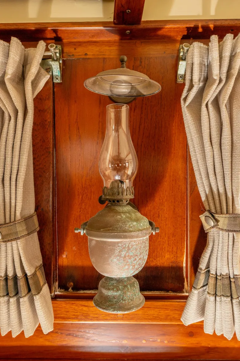 Slide: The Image of Vintage oil lamp on 1939 Stephens Brothers Bridgedeck Cruiser, framed by curtains. - 31
