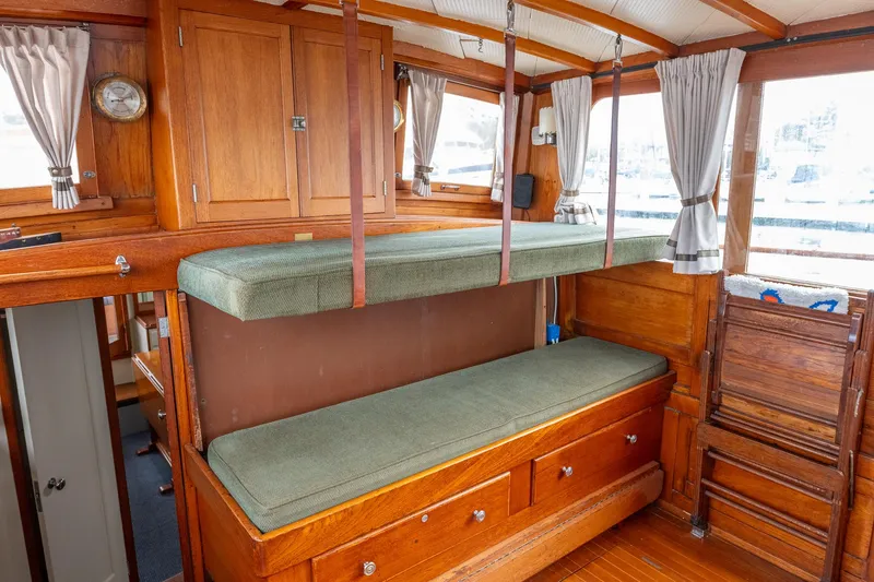 Slide: The Image of 1939 Stephens Brothers Bridgedeck Cruiser interior with wooden bunk beds and storage. - 49