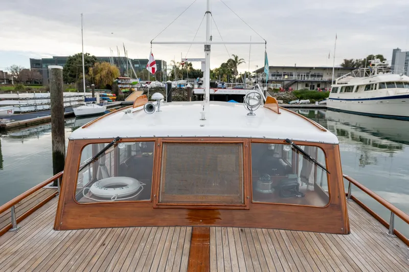 Slide: The Image of 1939 Stephens Brothers Bridgedeck Cruiser docked at marina, showcasing classic wooden design. - 8