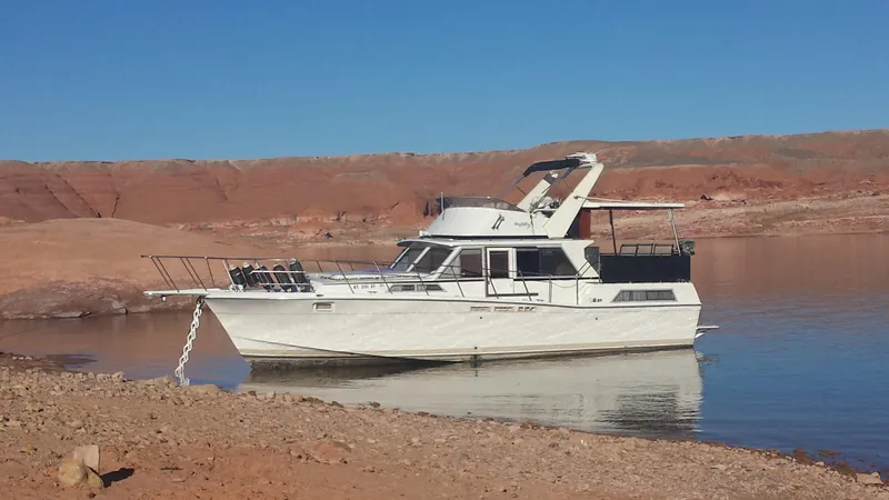The Image of 1975 Uniflite Aft Cabin yacht docked at marina under clear blue sky. - 0