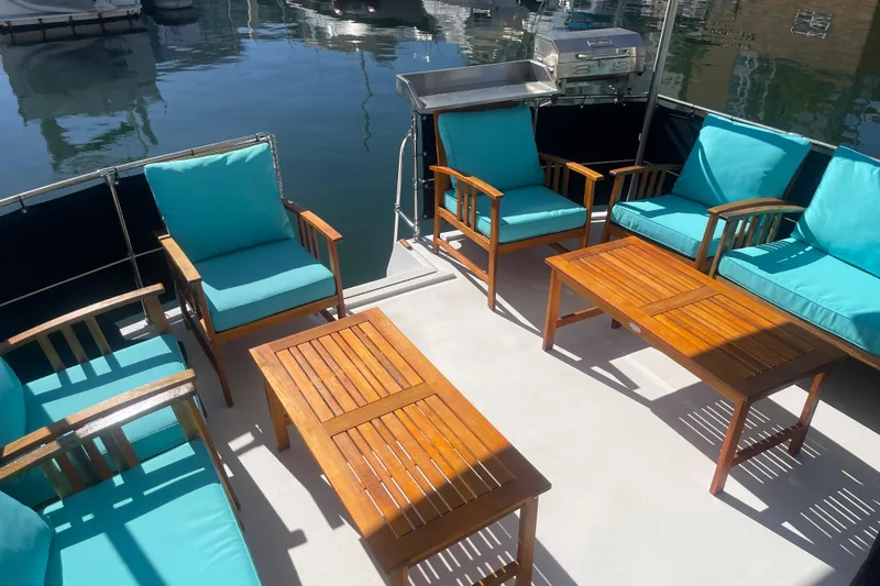 Slide: The Image of 1975 Uniflite Aft Cabin interior with cozy seating, wooden accents, and marina view. - 17