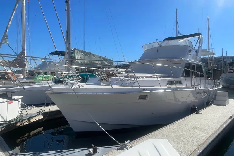 Slide: The Image of 1975 Uniflite Aft Cabin boat docked in a marina with a person on deck. - 3