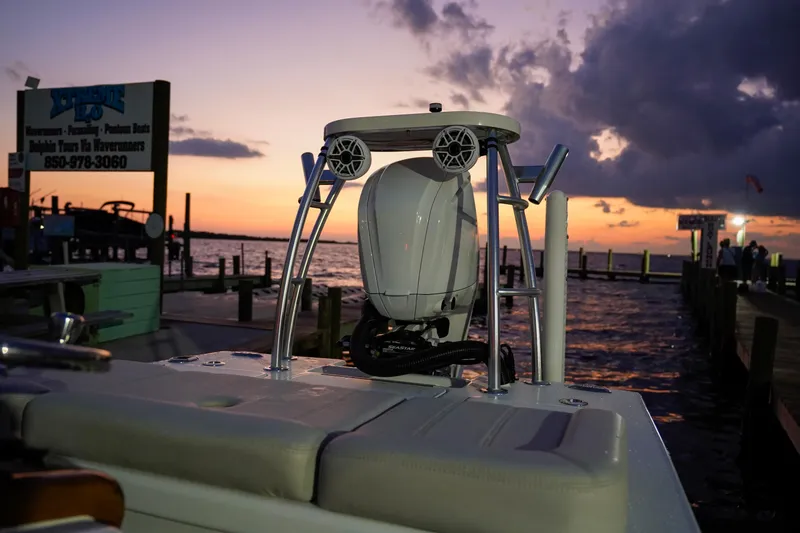 Slide: The Image of 2024 Xcelerator Boatworks 17 Flats at sunset by a dock. - 13