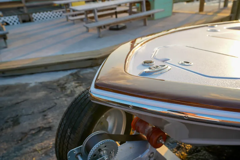 Slide: The Image of 2024 Xcelerator Boatworks 17 Flats boat on trailer, close-up view at sunset. - 7