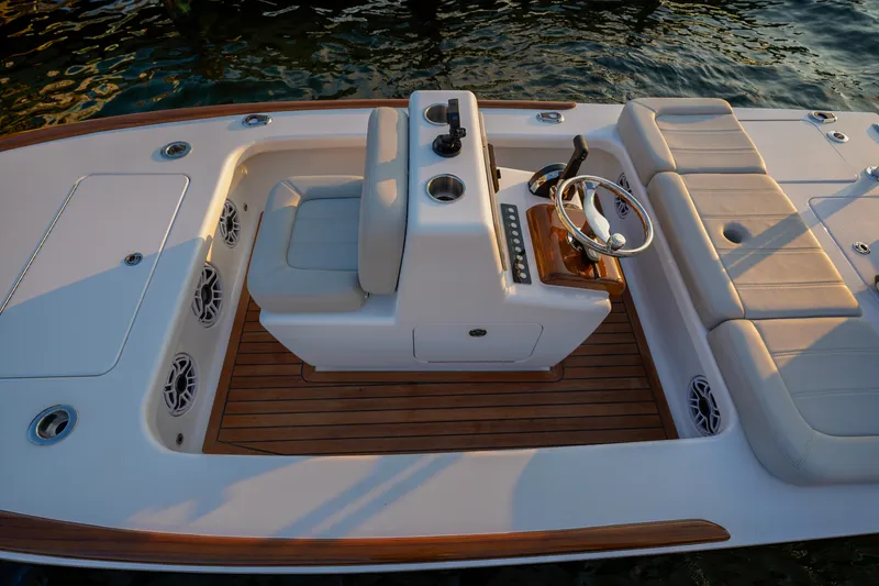Slide: The Image of 2024 Xcelerator Boatworks 17 Flats interior with seating and steering wheel, on water. - 8