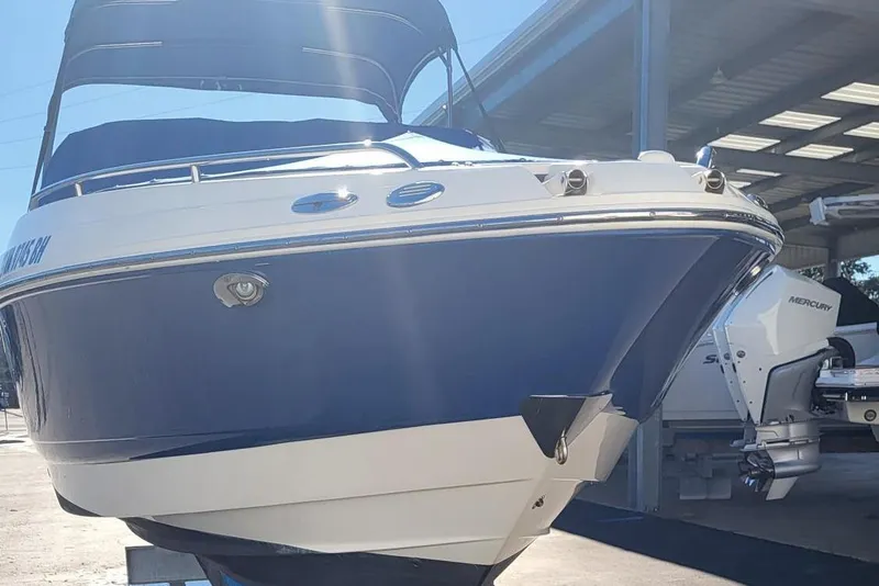 Slide: The Image of 2007 Chaparral 256 SSi boat with blue and white exterior, docked in a marina. - 16