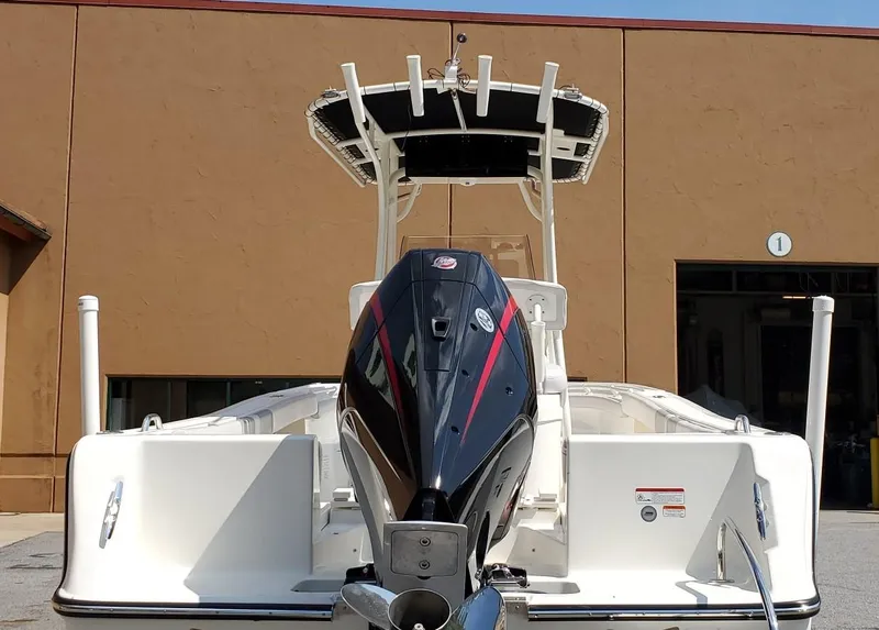 Slide: The Image of 2024 Mako 214 CC boat with powerful outboard motor, docked outdoors. - 9