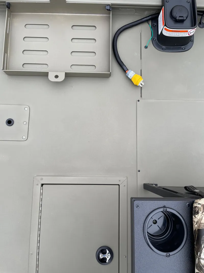 Slide: The Image of 2024 Tracker Grizzly 2072 CC Sportsman boat deck with storage compartments and wiring. - 5