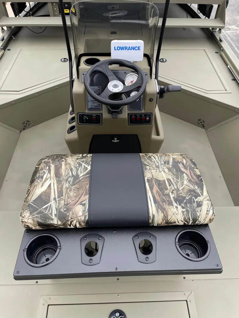 Slide: The Image of 2024 Tracker Grizzly 2072 CC Sportsman boat interior with camo seat and steering console. - 6