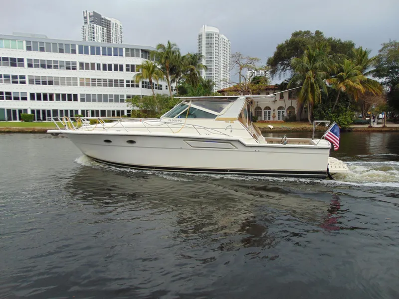 Slide: The Image of 1996 Tiara Yachts 4300 Open cruising on a waterway with cityscape background. - 2