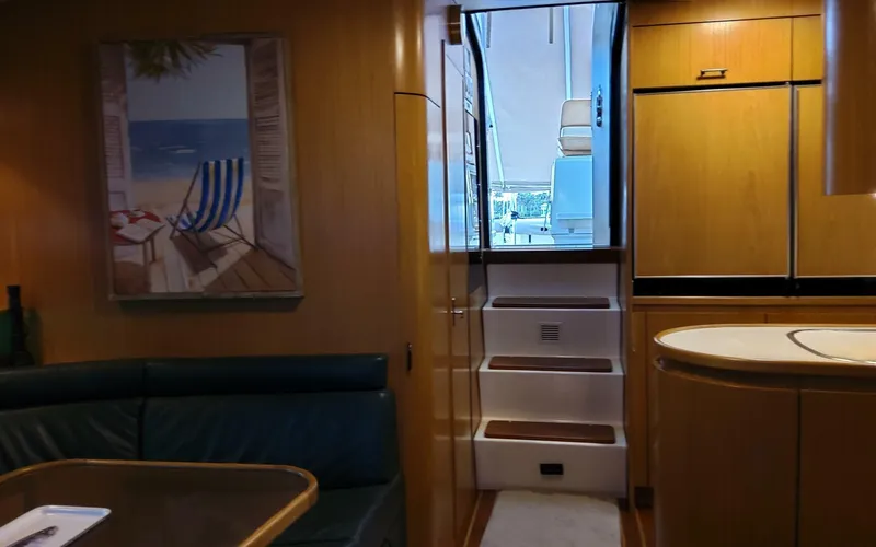 Slide: The Image of Interior of a 1996 Tiara Yachts 4300 Open, featuring a cozy dining area and steps to the deck. - 6