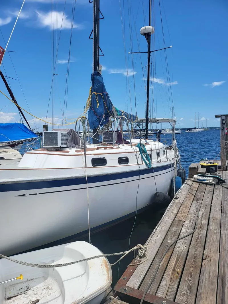 Slide: The Image of 1981 Allied Mistress Mk III sailboat docked at a marina on a sunny day. - 2